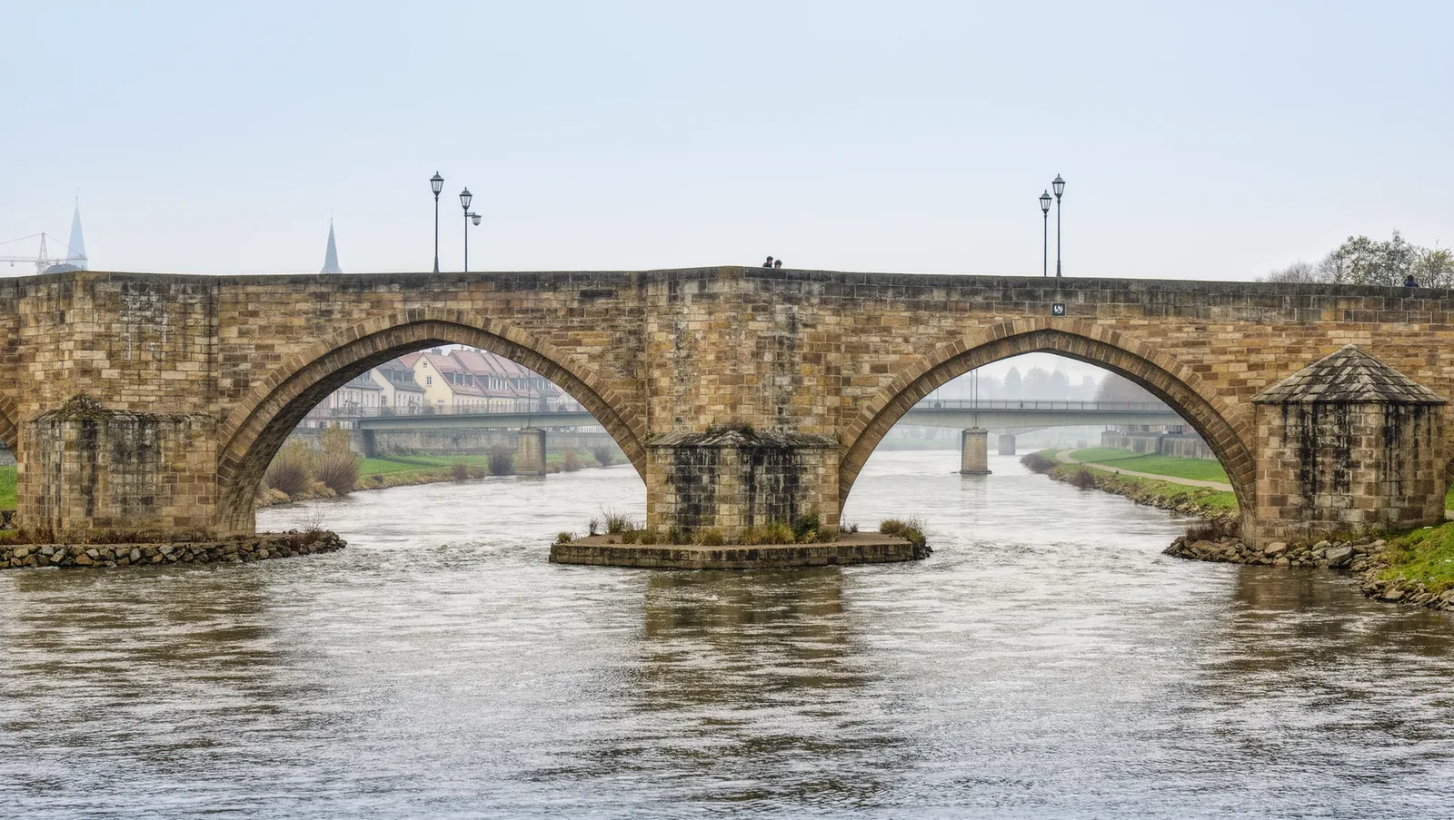 Symbolbild mittelalterliche Steinbrücke über einen Fluss